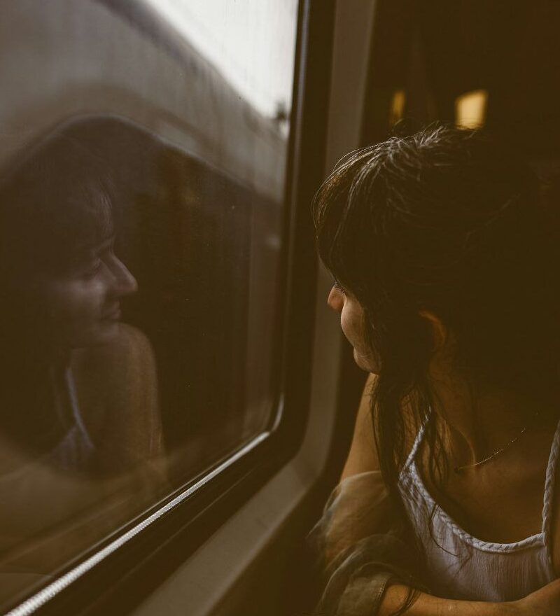 a woman sitting on a train looking out the window
